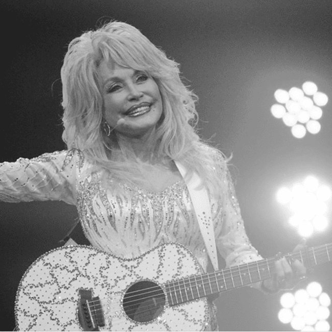 Dolly Parton mit Gitarre bei einem Bühnenauftritt